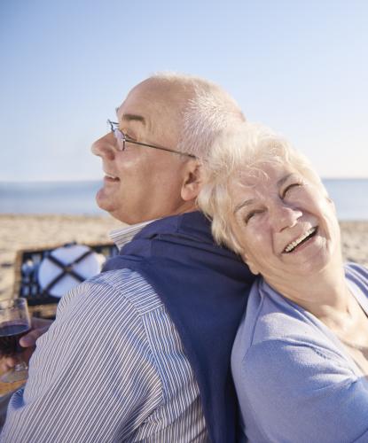 Coppia felice al mare con bicchiere di vino.